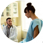 A doctor talks to a person in a hospital gown