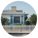 A one-story house with a white fence