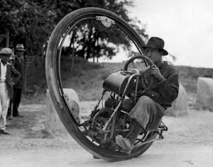Vintage portrait of a man riding a one wheel motor cycle