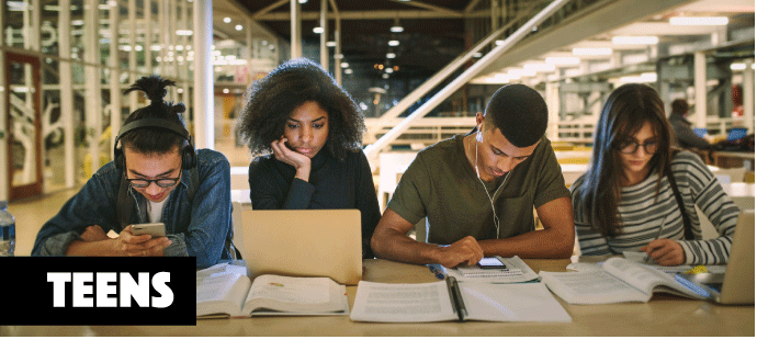 students working on homework at a table in a library