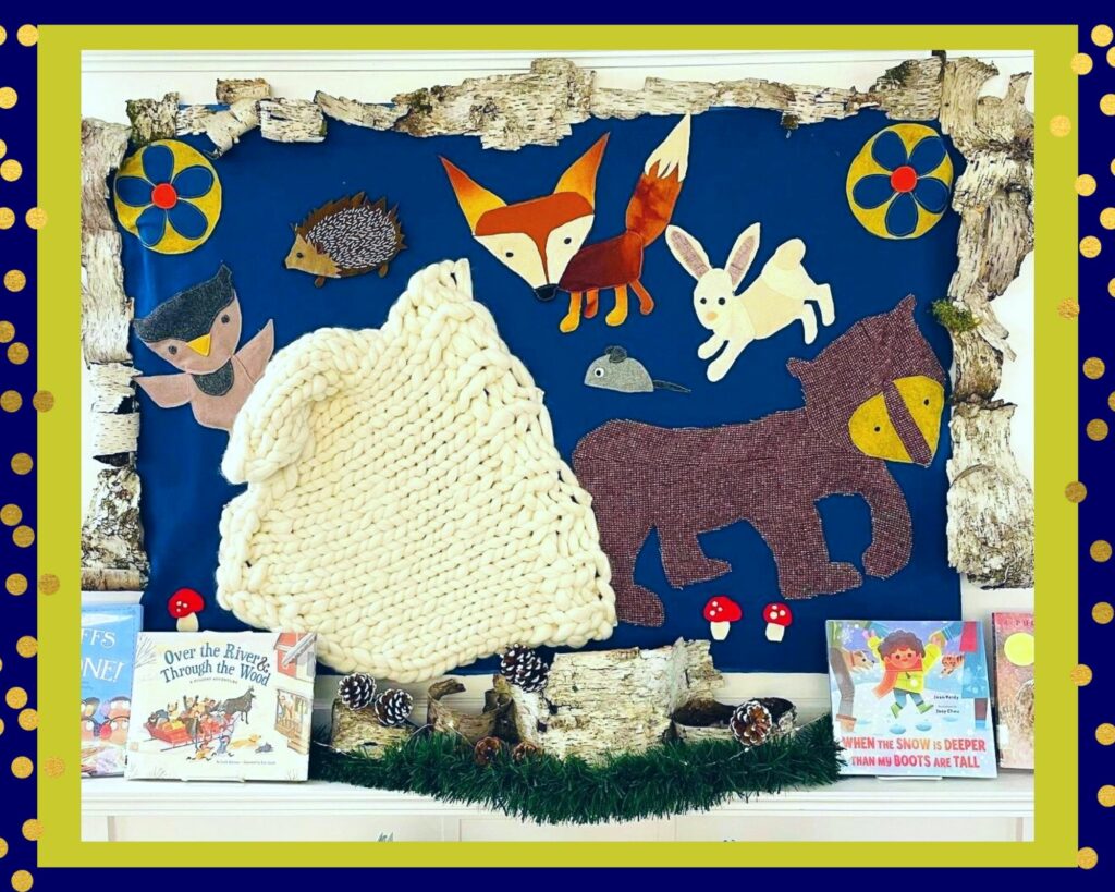 A photo of a library display featuring a fox, owl, hedgehog, and other animals in celebration of the story "The Mitten."