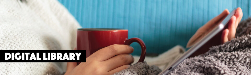 woman reads from an iPad under a blanket