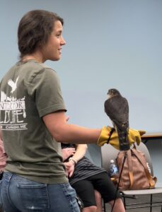 A representative from the Center for Wildlife holds a Peregrin Falcon to show to a group of children in the Children Library.