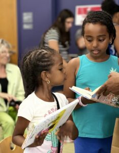 Two young girls with hold books during a Summer Reading event with author Gail Donovan.
