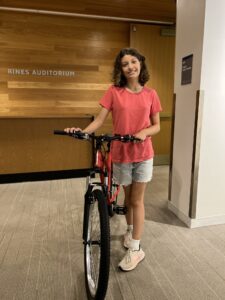 A young girl stands with a new bicycle—her prize from participating in PPL Summer Reading