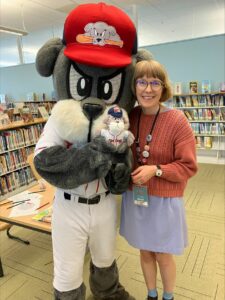 Slugger the Portland Seadogs mascot poses for a photo in the Children's Library with Director of Youth Services, Kelley Blue.