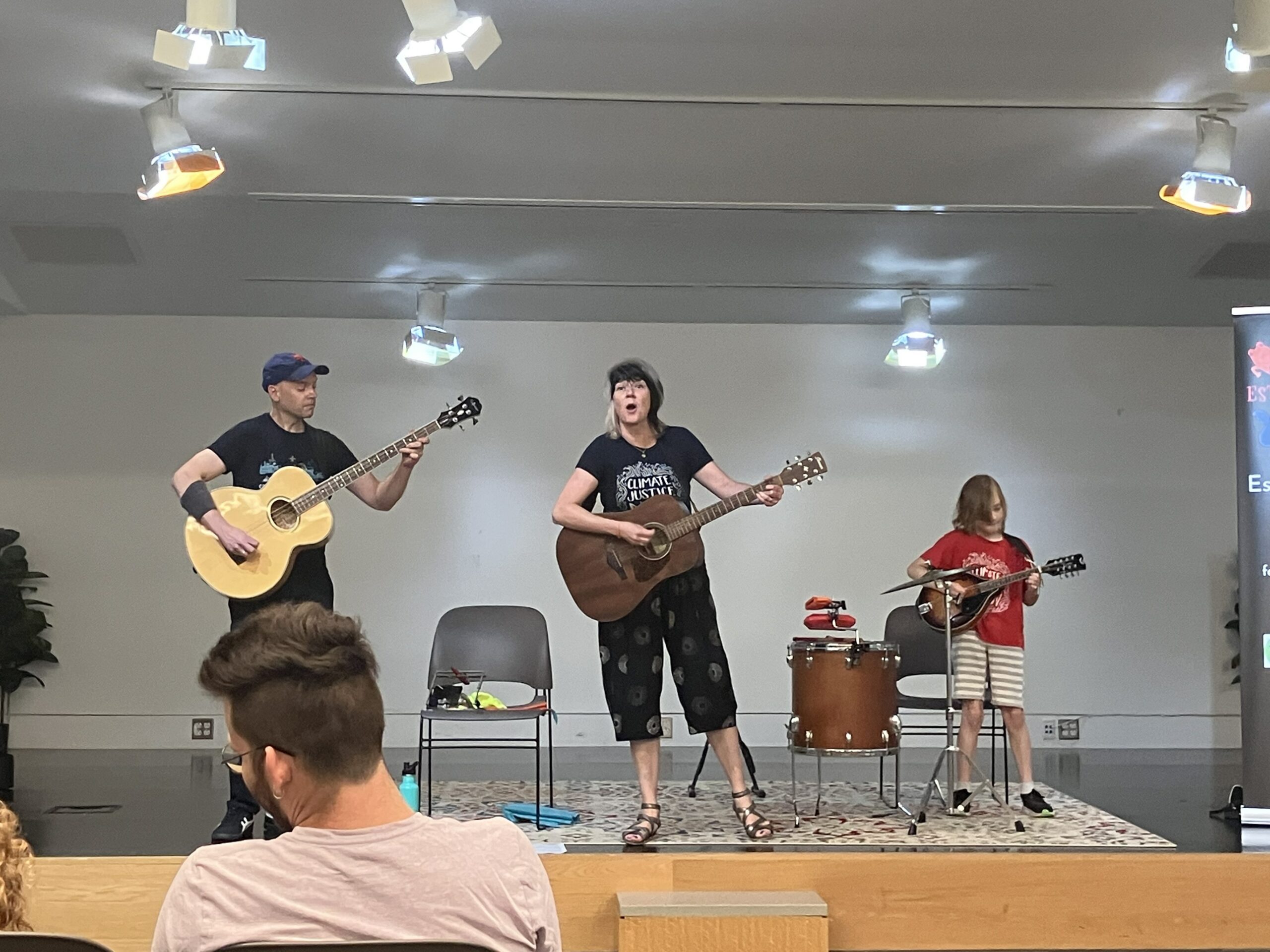 A family band plays a concert about climate change on stage in the Rines Auditorium at the Downtown Library