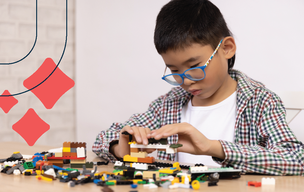 Young boy concentrates on building a spectacular lego creation