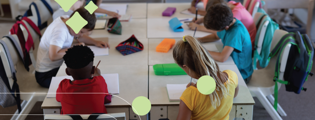 A decorative image of kids writing at a large table with their backpacks hanging over their chairs